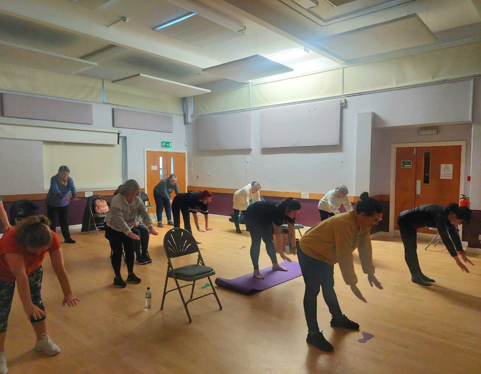 Indoor class setting, a group class following the direction of Hannah beautifully in sync.