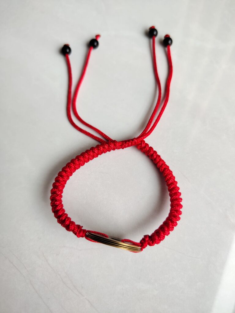 Five Emperor Coins Red Cord Bracelet handmade with traditional Vajra Knot, adjustable Chinese Feng Shui jewelry for protection.