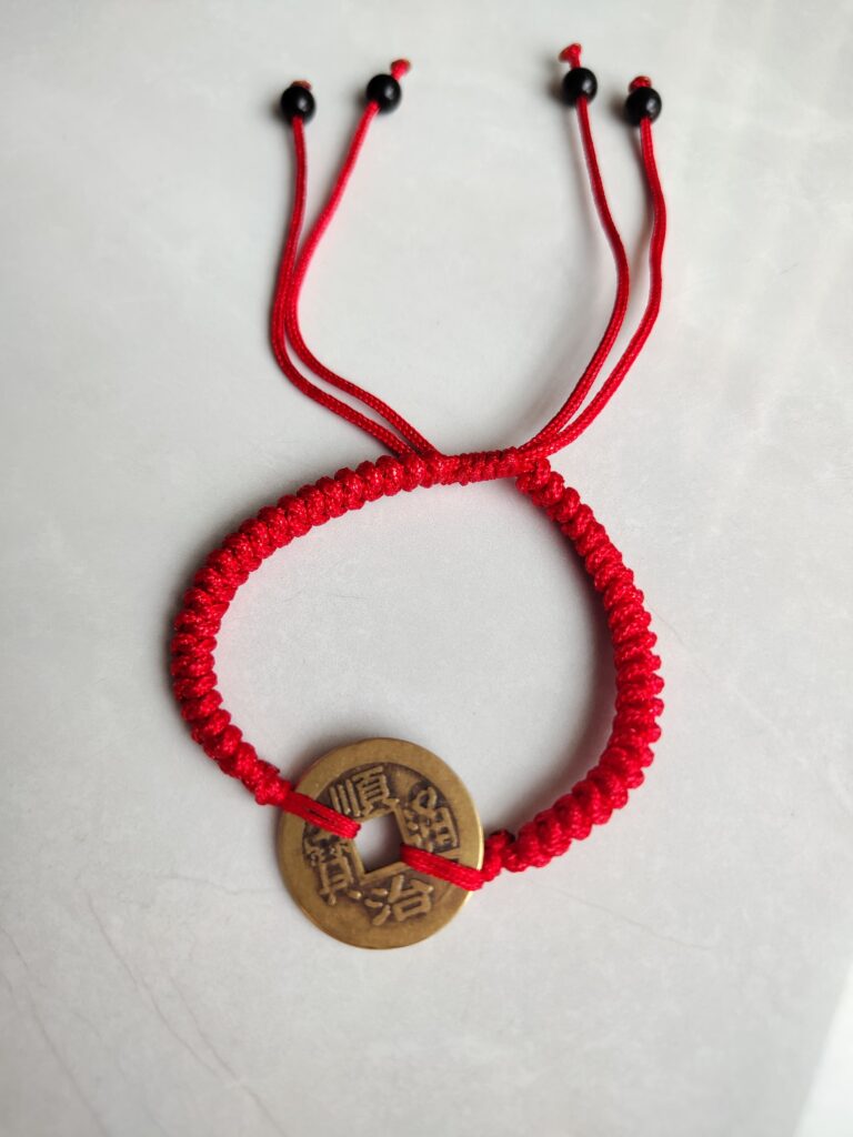Five Emperor Coins Red Cord Bracelet handmade with traditional Vajra Knot, adjustable Chinese Feng Shui jewelry for protection.
