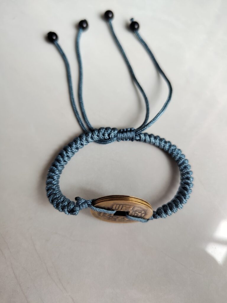 Five Emperor Coins Dusty Blue Cord Bracelet handmade with traditional Vajra Knot, adjustable Chinese Feng Shui jewelry for protection.