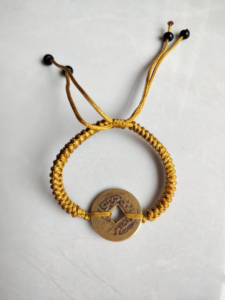 Five Emperor Coins Earth Yellow Cord Bracelet handmade with traditional Vajra Knot, adjustable Chinese Feng Shui jewelry for protection.