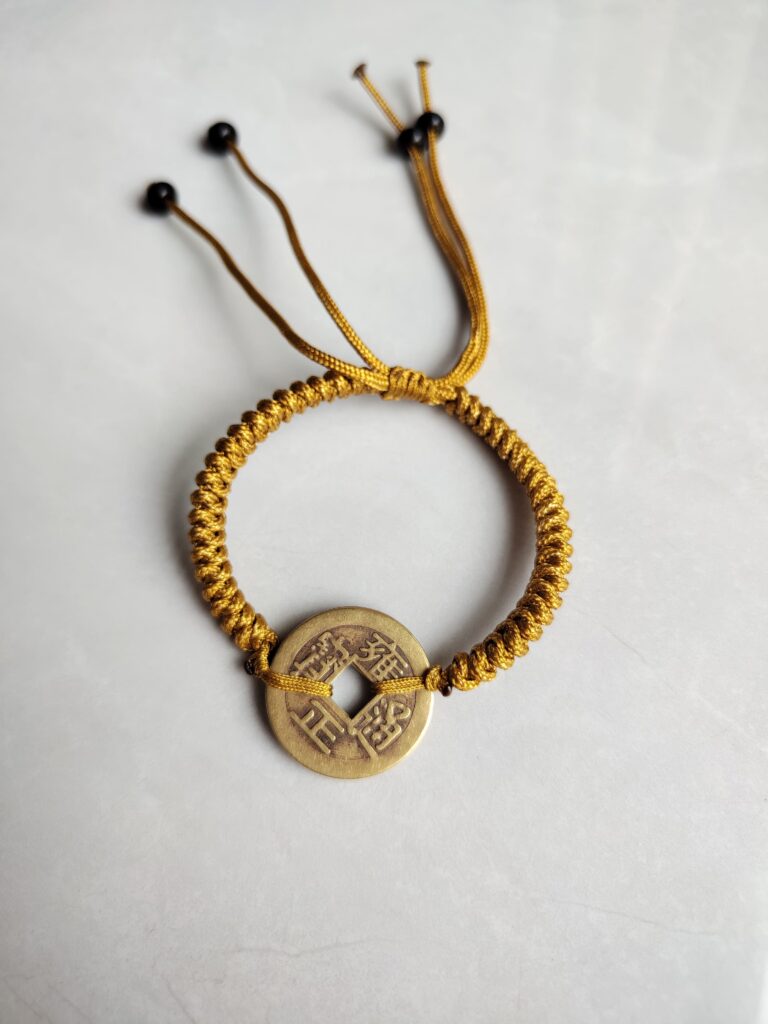 Five Emperor Coins Earth Yellow Cord Bracelet handmade with traditional Vajra Knot, adjustable Chinese Feng Shui jewelry for protection.