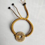Five Emperor Coins Earth Yellow Cord Bracelet handmade with traditional Vajra Knot, adjustable Chinese Feng Shui jewelry for protection.