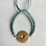 Five Emperor Coins Olive Green Cord Bracelet handmade with traditional Vajra Knot, adjustable Chinese Feng Shui jewelry for protection.