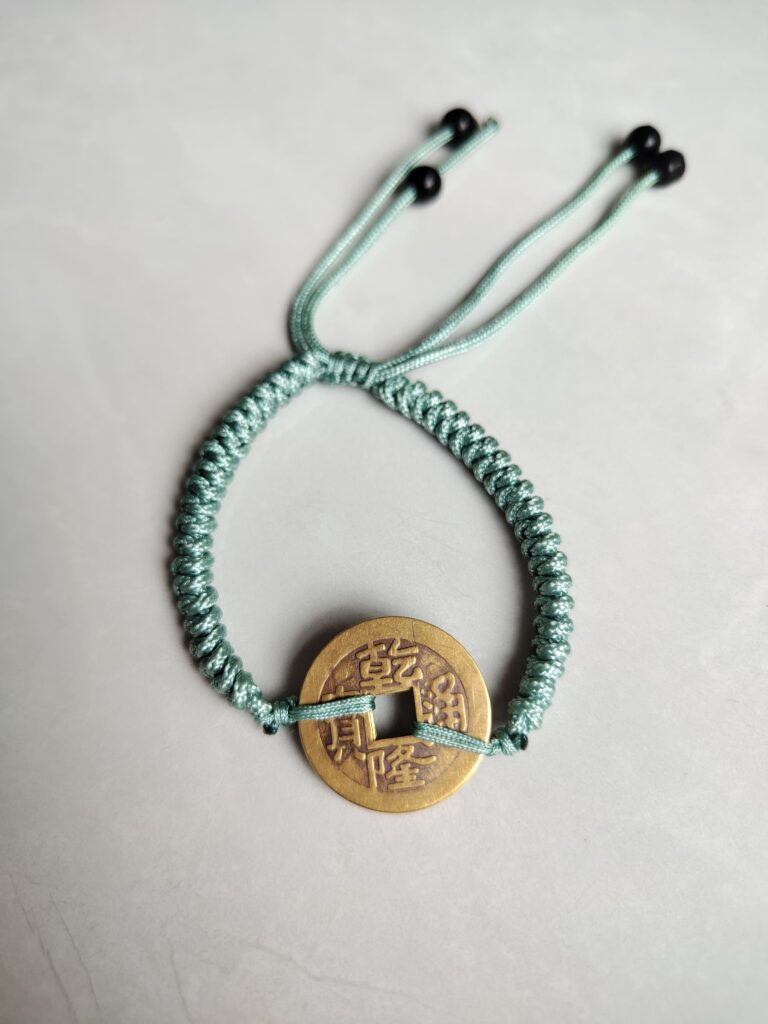 Five Emperor Coins Olive Green Cord Bracelet handmade with traditional Vajra Knot, adjustable Chinese Feng Shui jewelry for protection.