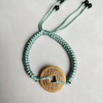 Five Emperor Coins Olive Green Cord Bracelet handmade with traditional Vajra Knot, adjustable Chinese Feng Shui jewelry for protection.
