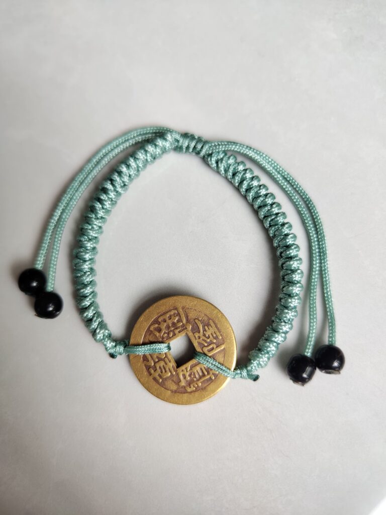 Five Emperor Coins Olive Green Cord Bracelet handmade with traditional Vajra Knot, adjustable Chinese Feng Shui jewelry for protection.