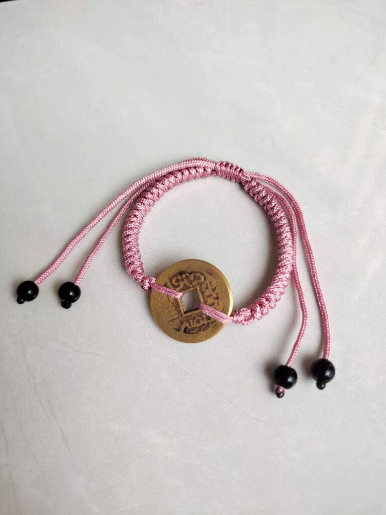 Five Emperor Coins Peach Pink Cord Bracelet handmade with traditional Vajra Knot, adjustable Chinese Feng Shui jewelry for protection.