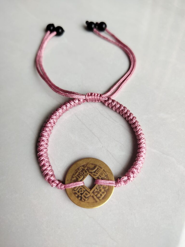 Five Emperor Coins Peach Pink Cord Bracelet handmade with traditional Vajra Knot, adjustable Chinese Feng Shui jewelry for protection.
